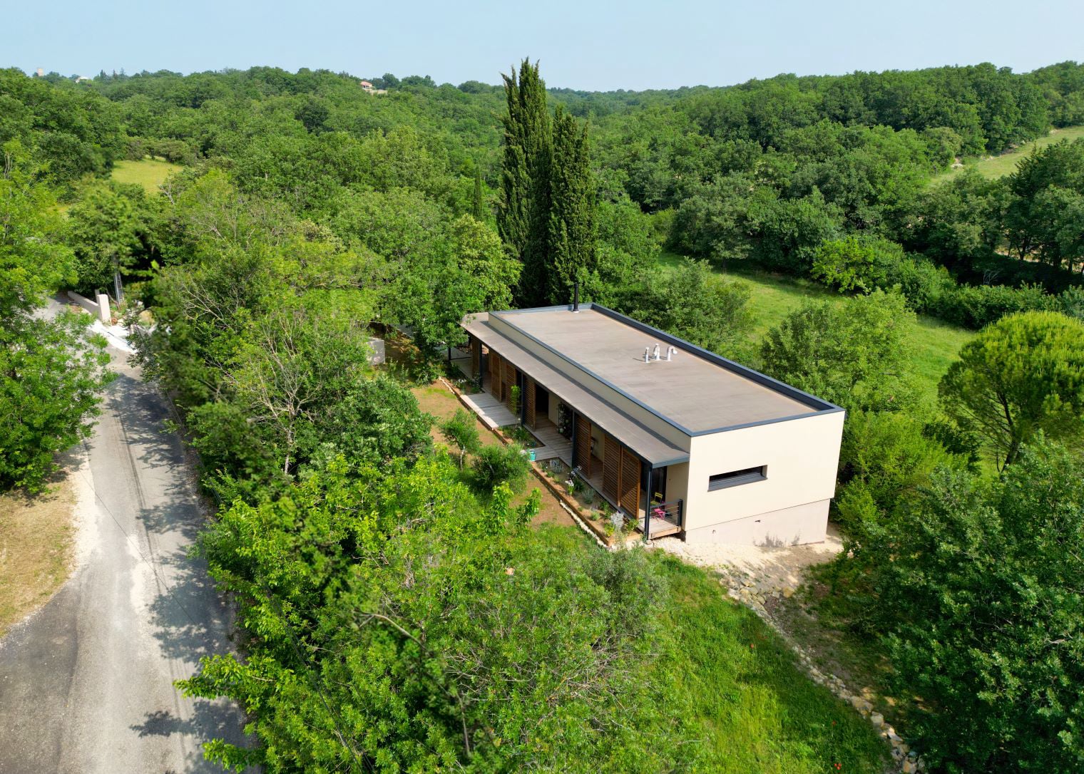 Maison familiale intégrée dans l’environnement, conçue par l'architecte Benoît Gilet sur un terrain en pente.