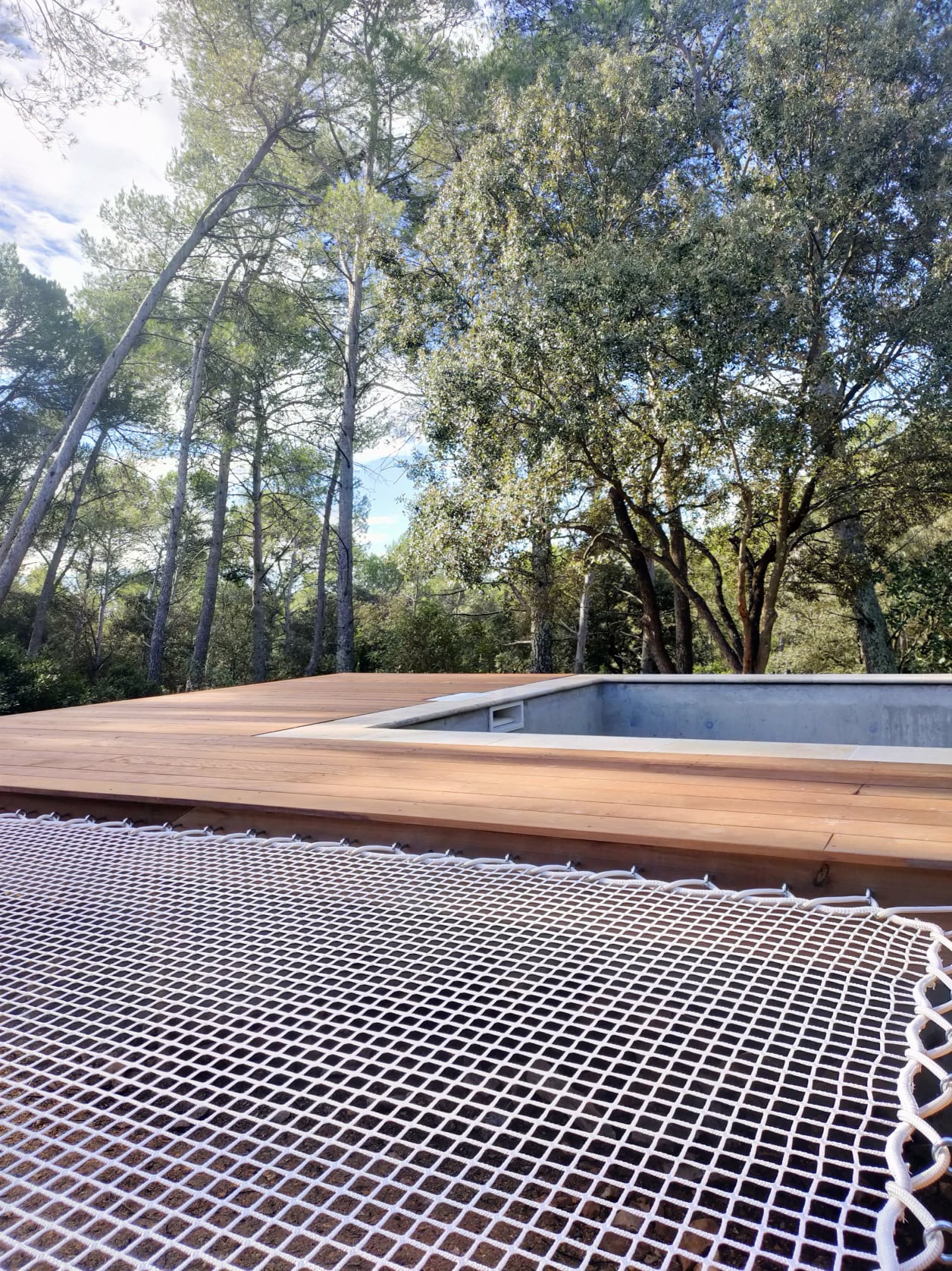 Piscine avec filet de détente dans espace naturel, réalisé par Home habilis.